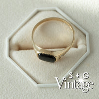 Gold ring with a black stone on a hexagonal white stand, branded 'S + G Vintage' - seolgold
