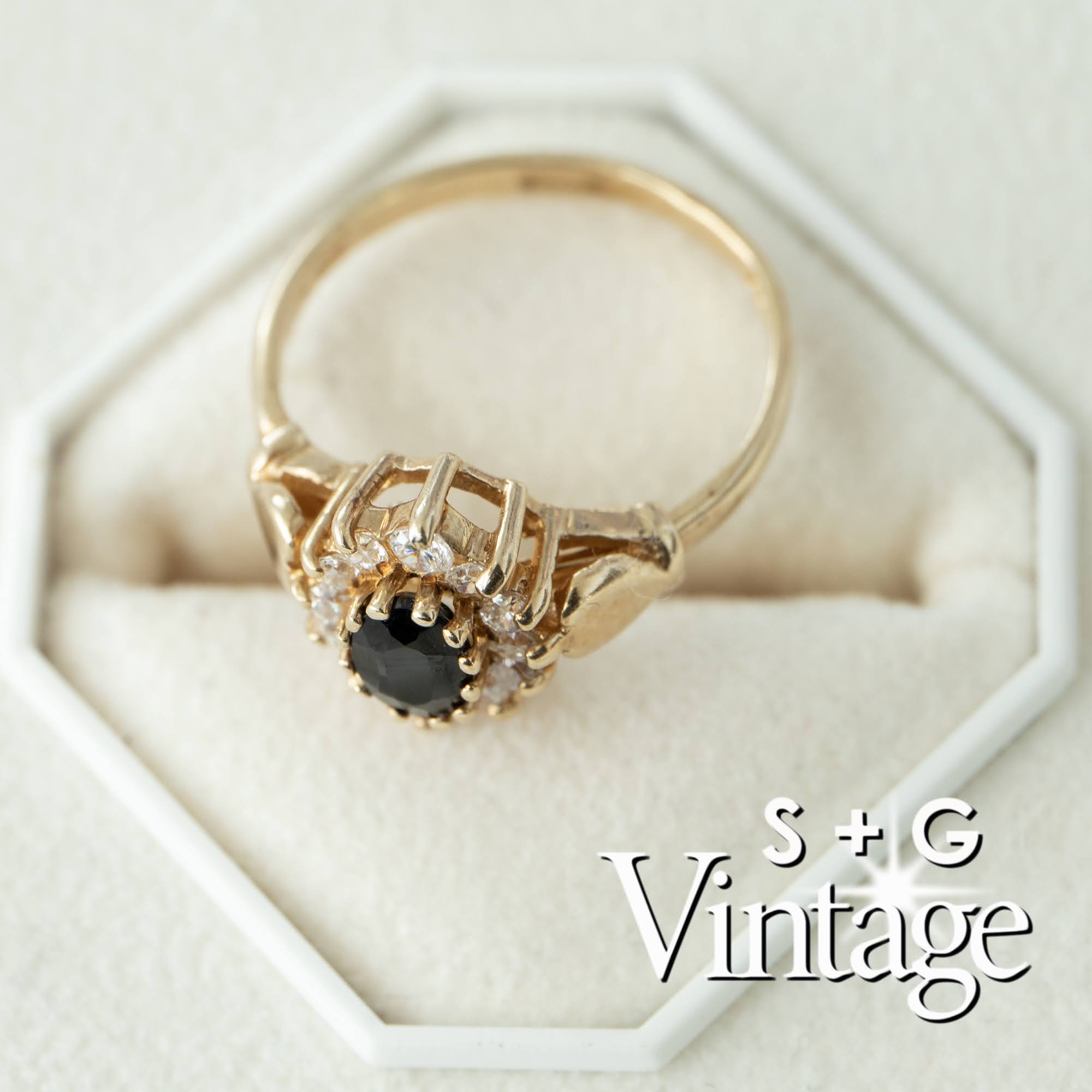 Gold ring with a black gemstone on a white hexagonal stand, branded 'S + G Vintage' - seolgold
