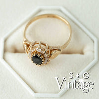 Gold ring with a black gemstone on a white hexagonal stand, branded 'S + G Vintage' - seolgold
