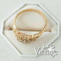 Gold ring with intricate design on a white hexagonal stand, featuring 'S + G Vintage' branding - seolgold