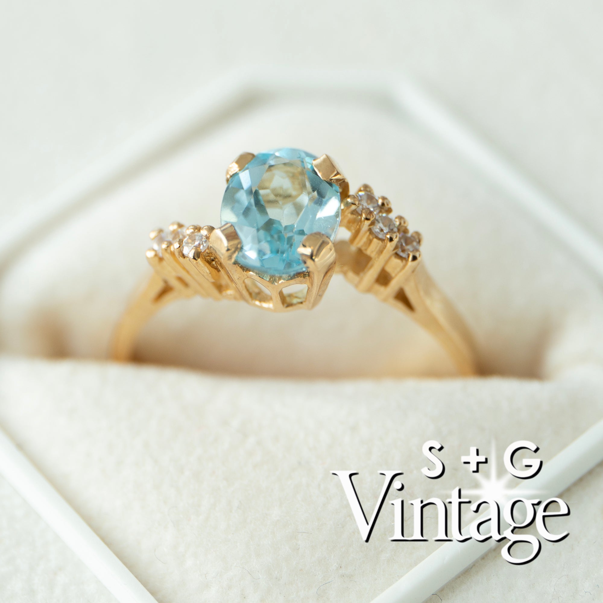 Gold ring with a blue gemstone on a white background, featuring 'S + G Vintage' branding - seolgold