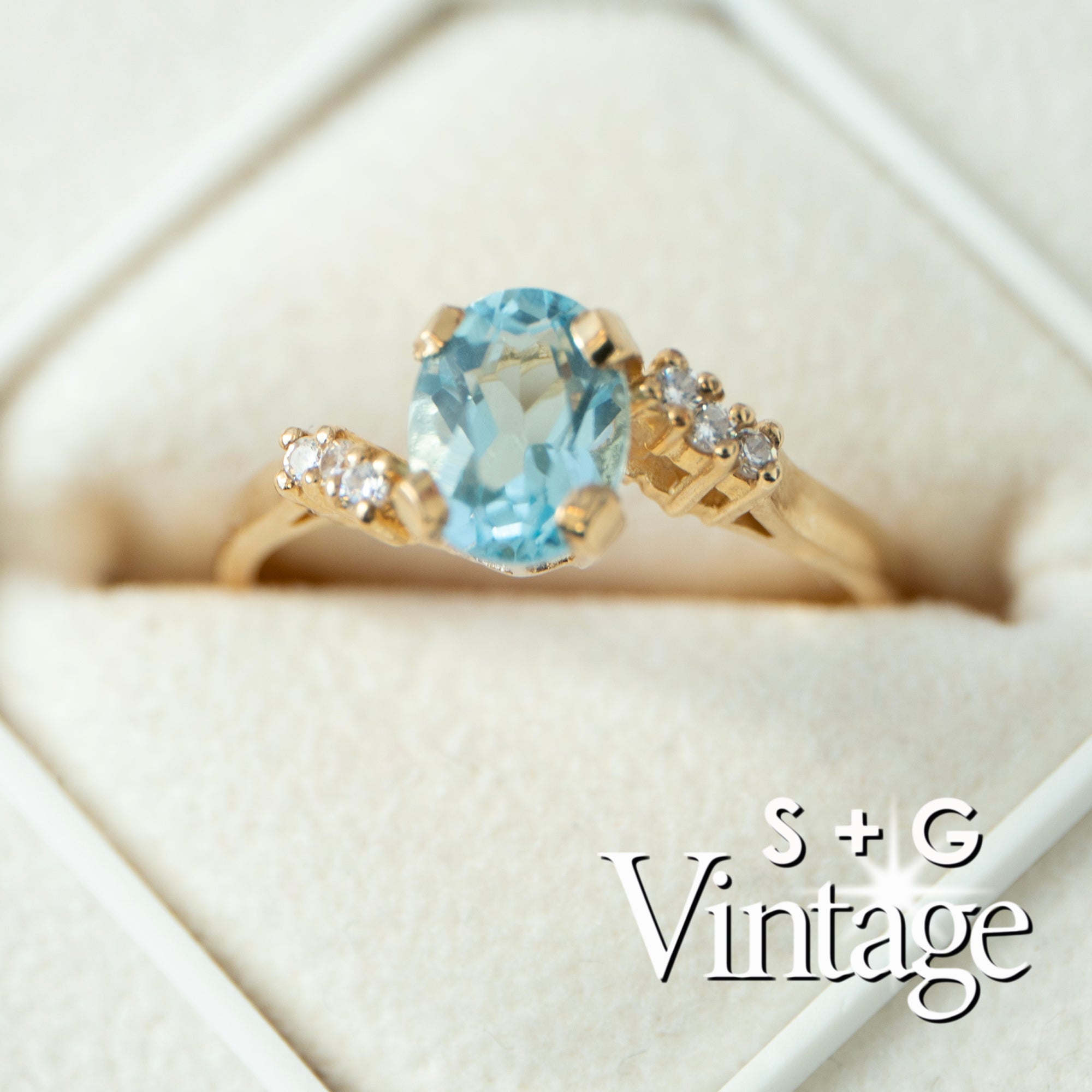Gold ring with a blue gemstone and diamonds on a white background, featuring 'S + G Vintage' branding - seolgold