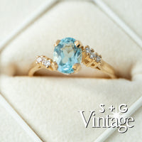 Gold ring with a blue gemstone and diamonds on a white background, featuring 'S + G Vintage' branding - seolgold
