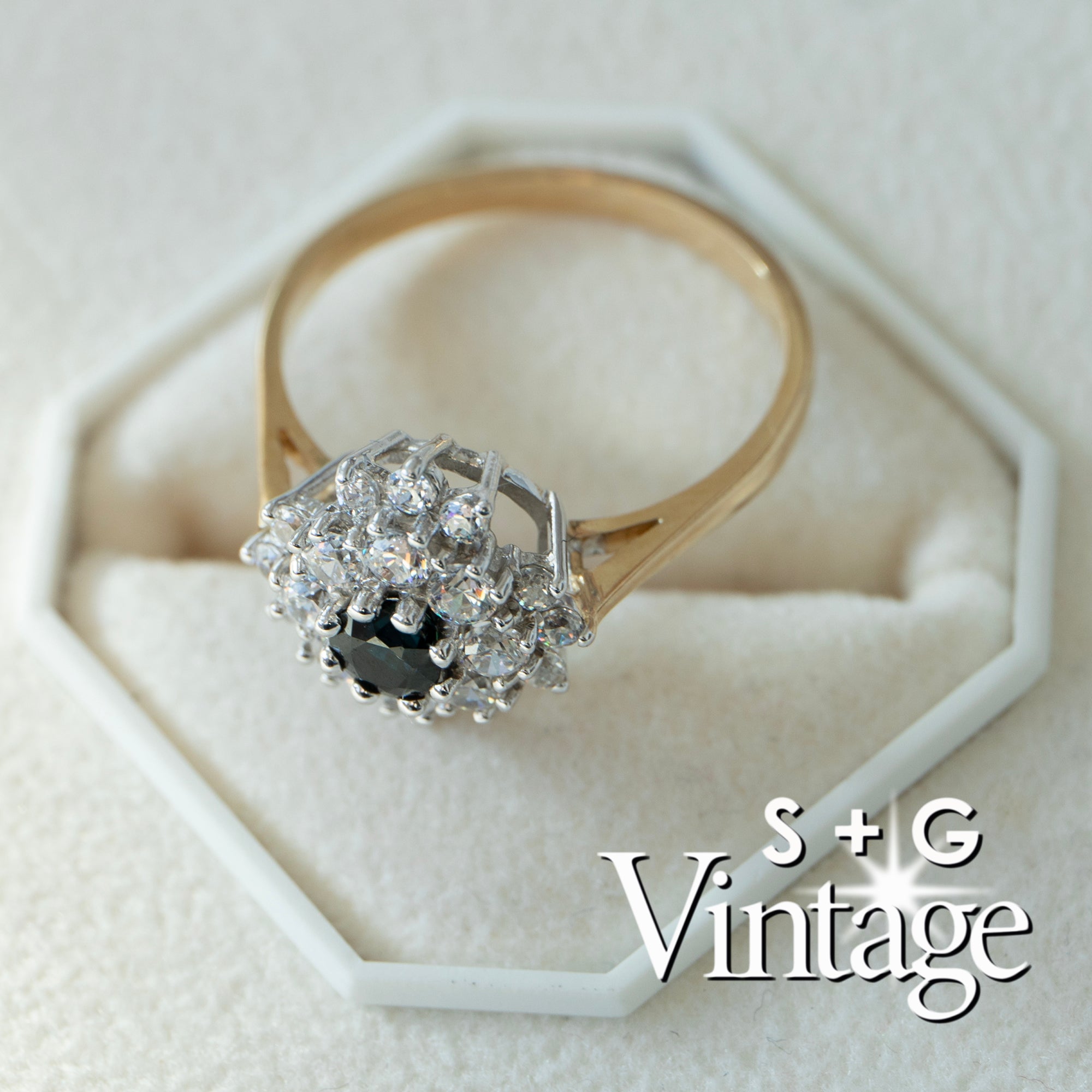 Gold ring with diamond cluster on a white hexagonal stand, branded 'S + G Vintage' - seolgold