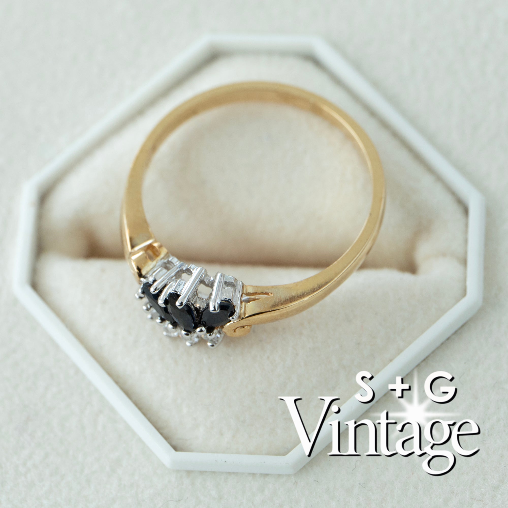 Gold ring with a black gemstone on a white hexagonal stand, branded 'S + G Vintage' - seolgold