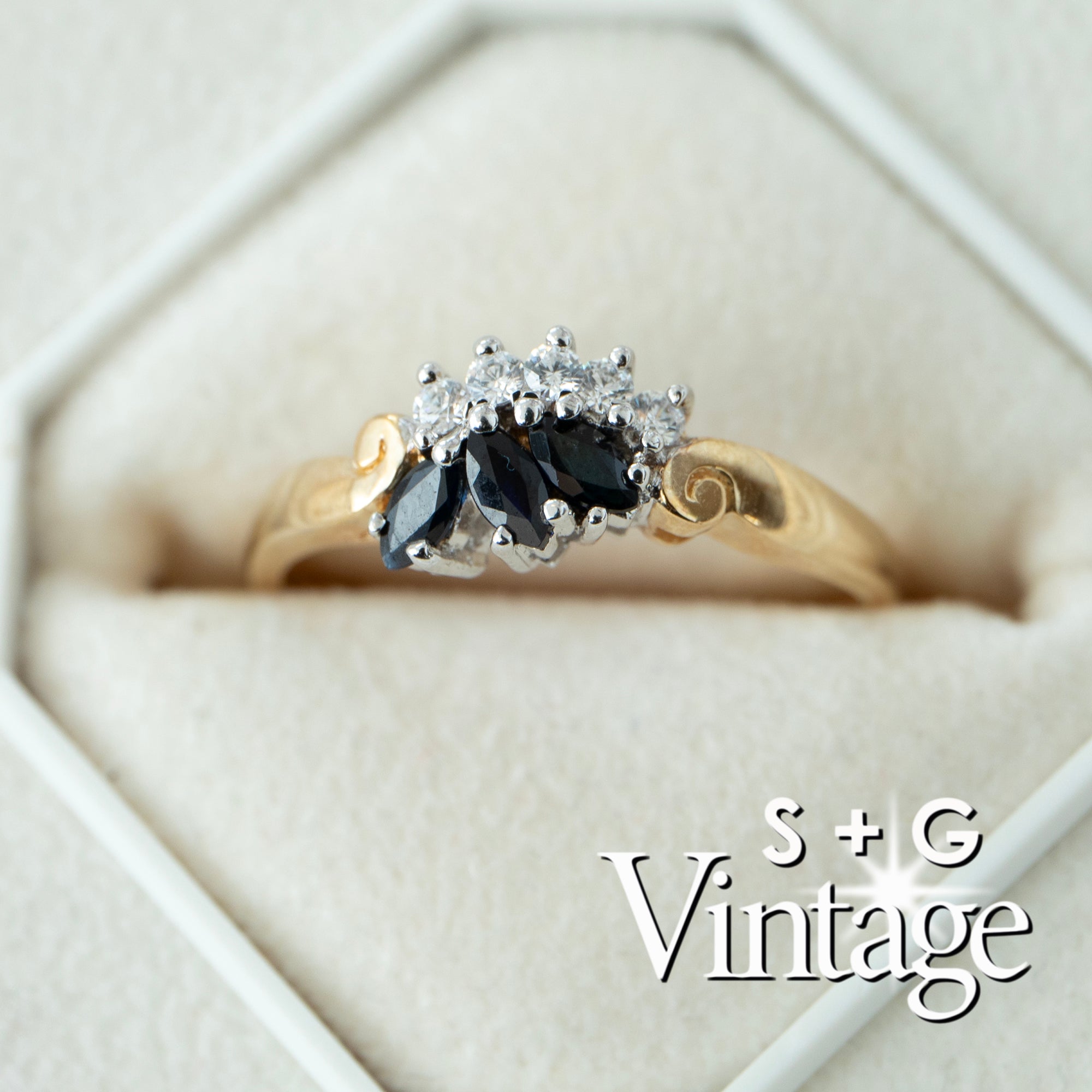 Gold ring with black gemstone and diamonds in a hexagonal box, featuring 'S + G Vintage' branding - seolgold