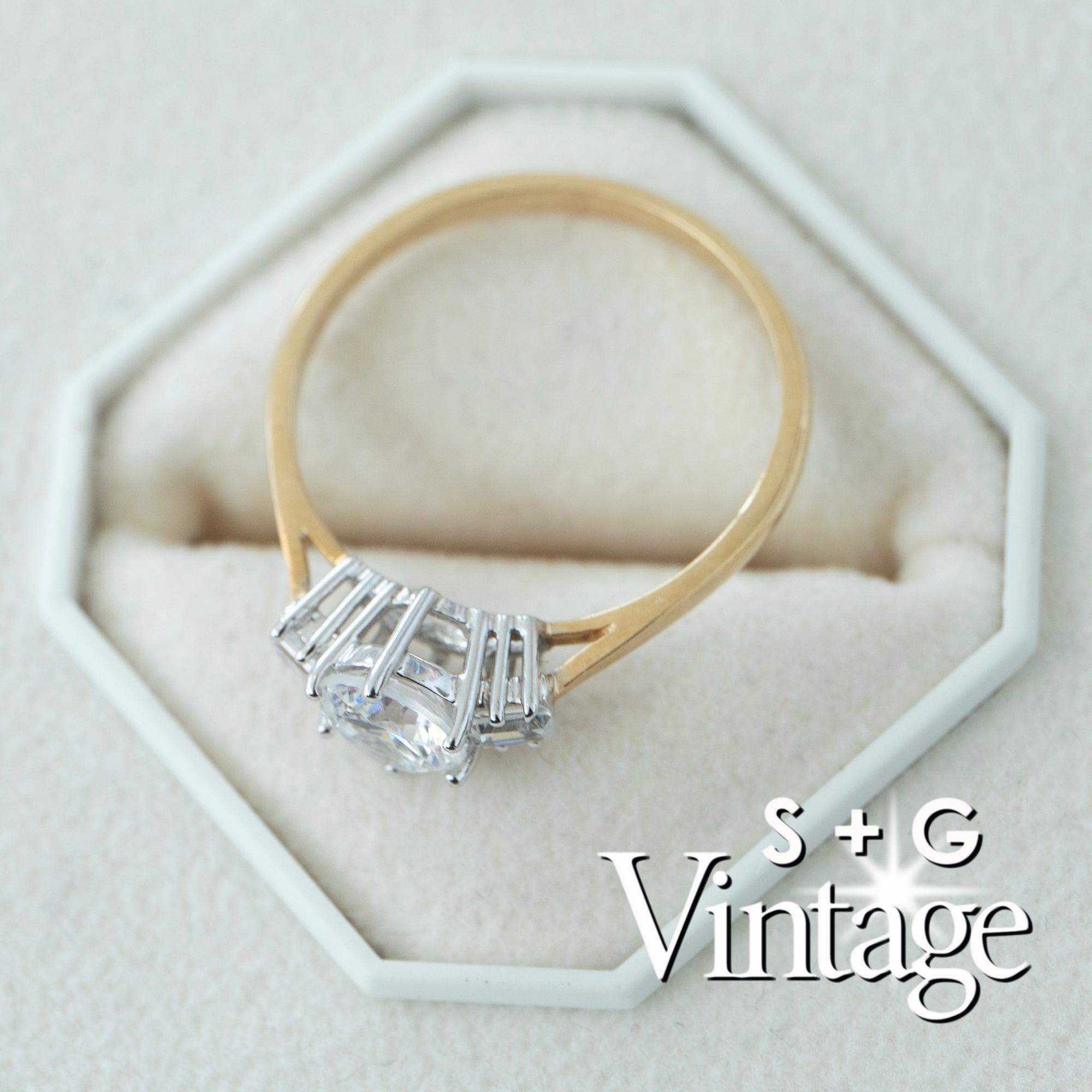Gold ring with a diamond on a white hexagonal stand, featuring 'S + G Vintage' branding - seolgold
