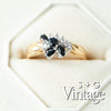 Gold ring with black gemstones and diamonds on a white background, featuring 'S + G Vintage' branding - seolgold