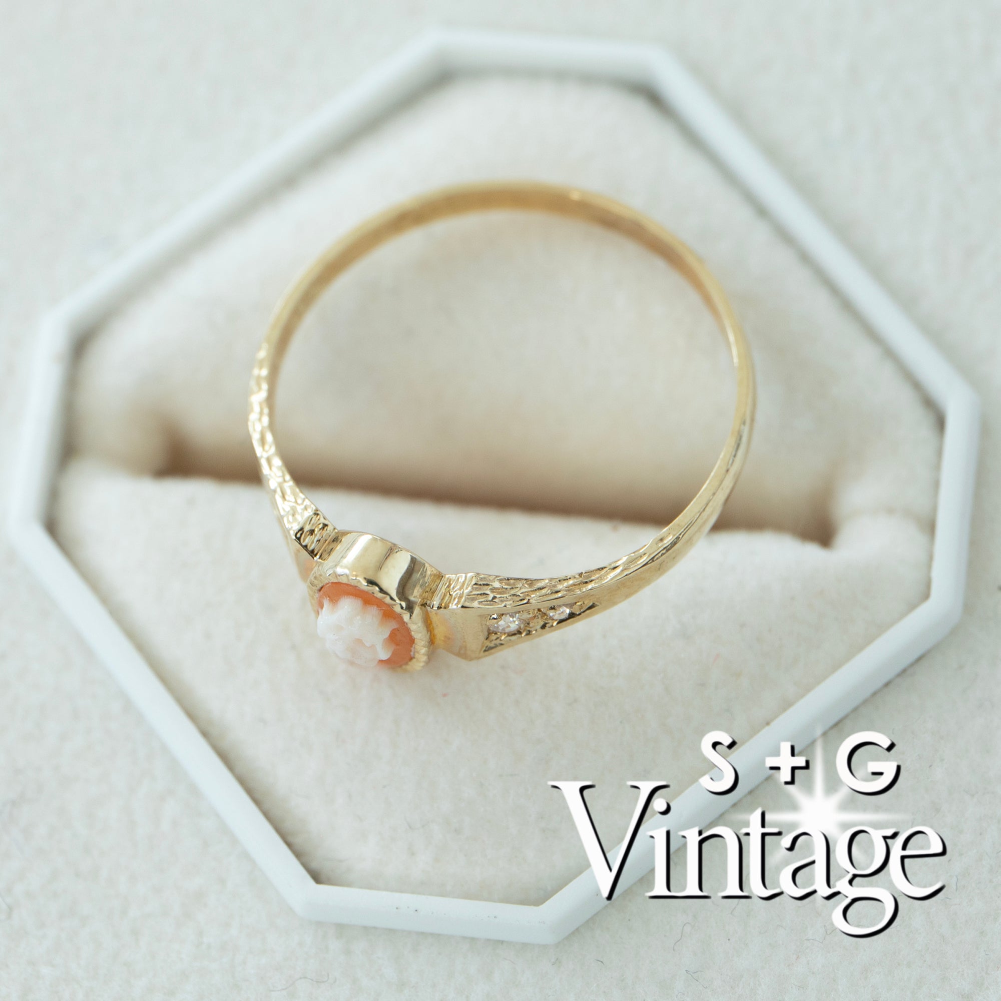 Gold ring with a cameo on a white hexagonal stand, featuring 'S + G Vintage' branding - seolgold