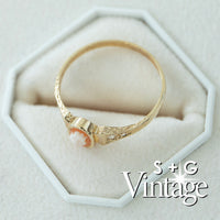 Gold ring with a cameo on a white hexagonal stand, featuring 'S + G Vintage' branding - seolgold