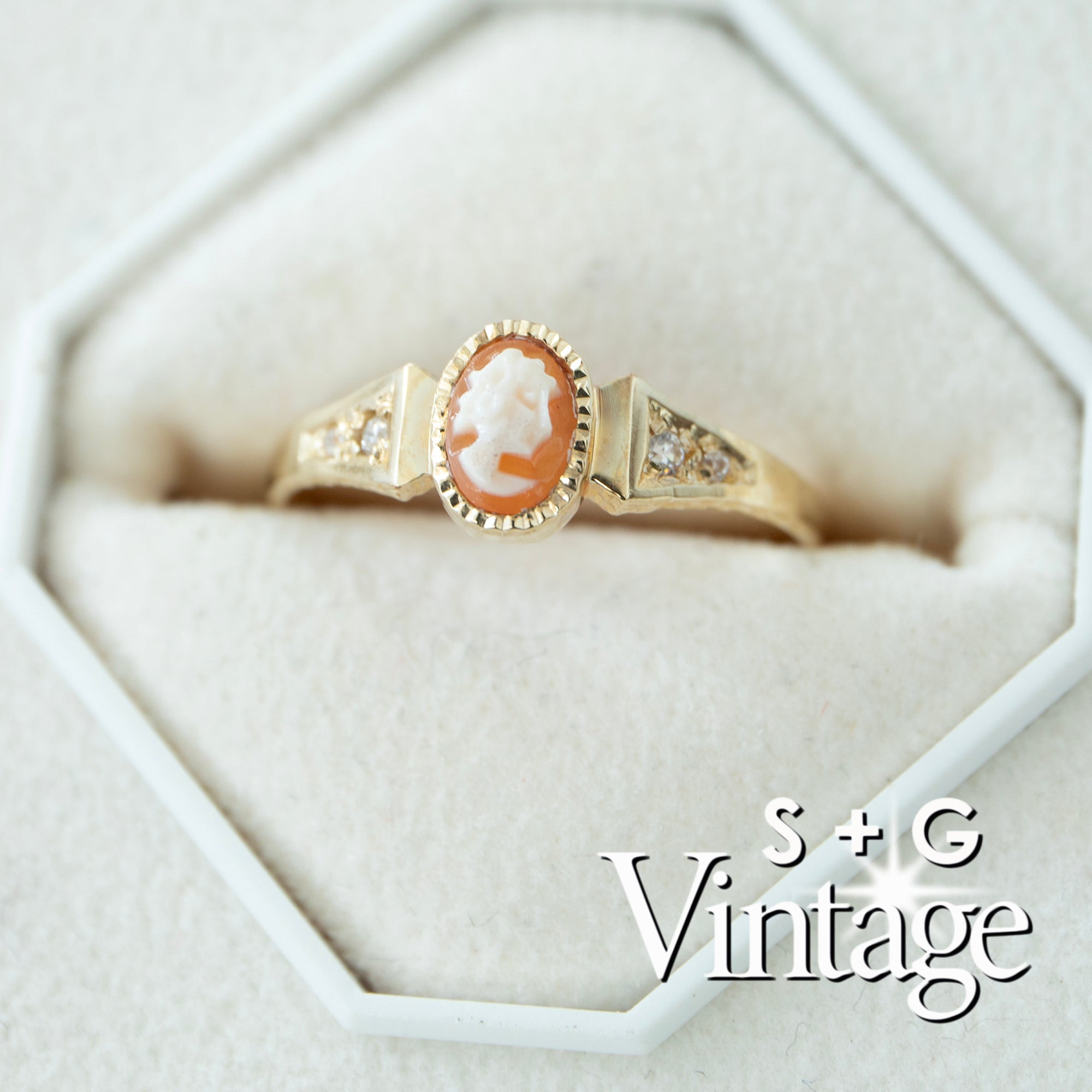 Vintage-style gold ring with a cameo center stone on a white background, featuring 'S + G Vintage' branding - seolgold
