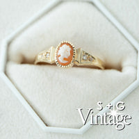 Vintage-style gold ring with a cameo center stone on a white background, featuring 'S + G Vintage' branding - seolgold