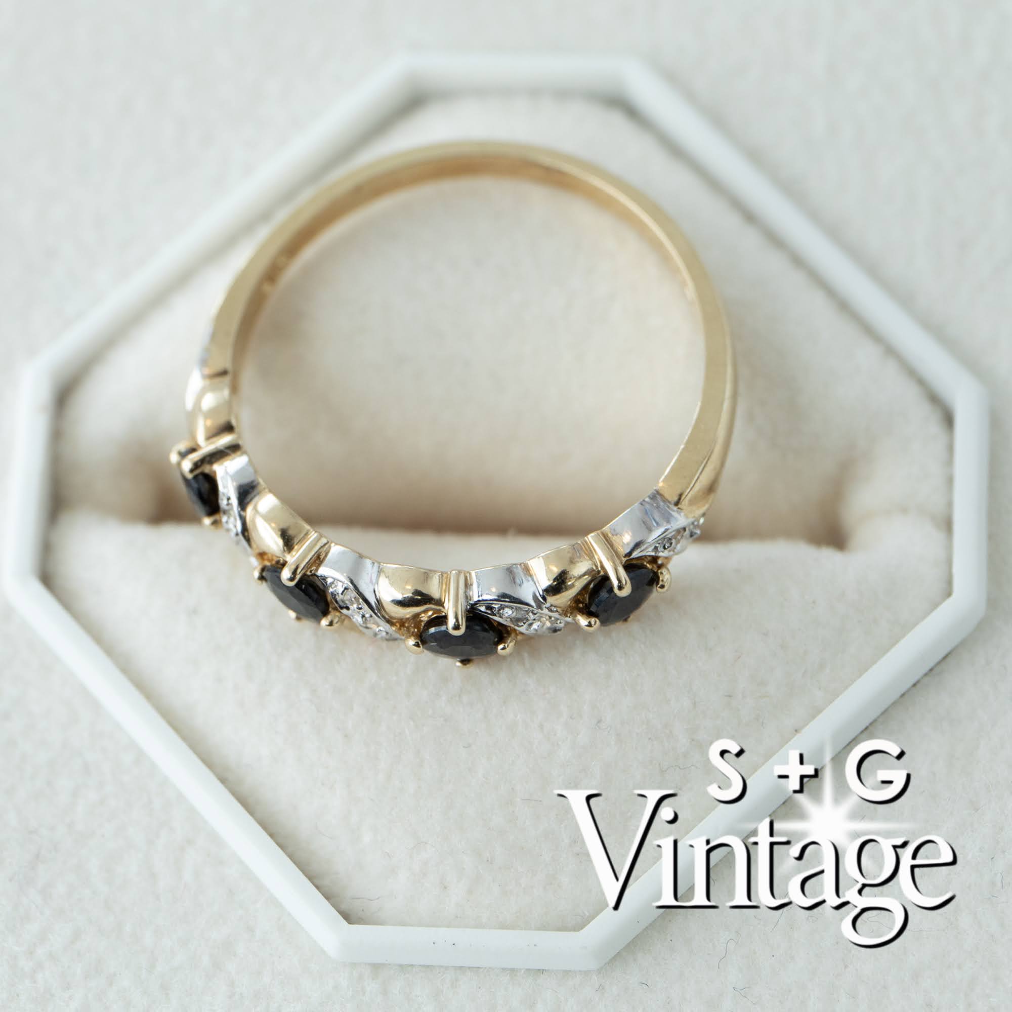 Gold ring with black stones on a white hexagonal stand, branded 'S + G Vintage' - seolgold