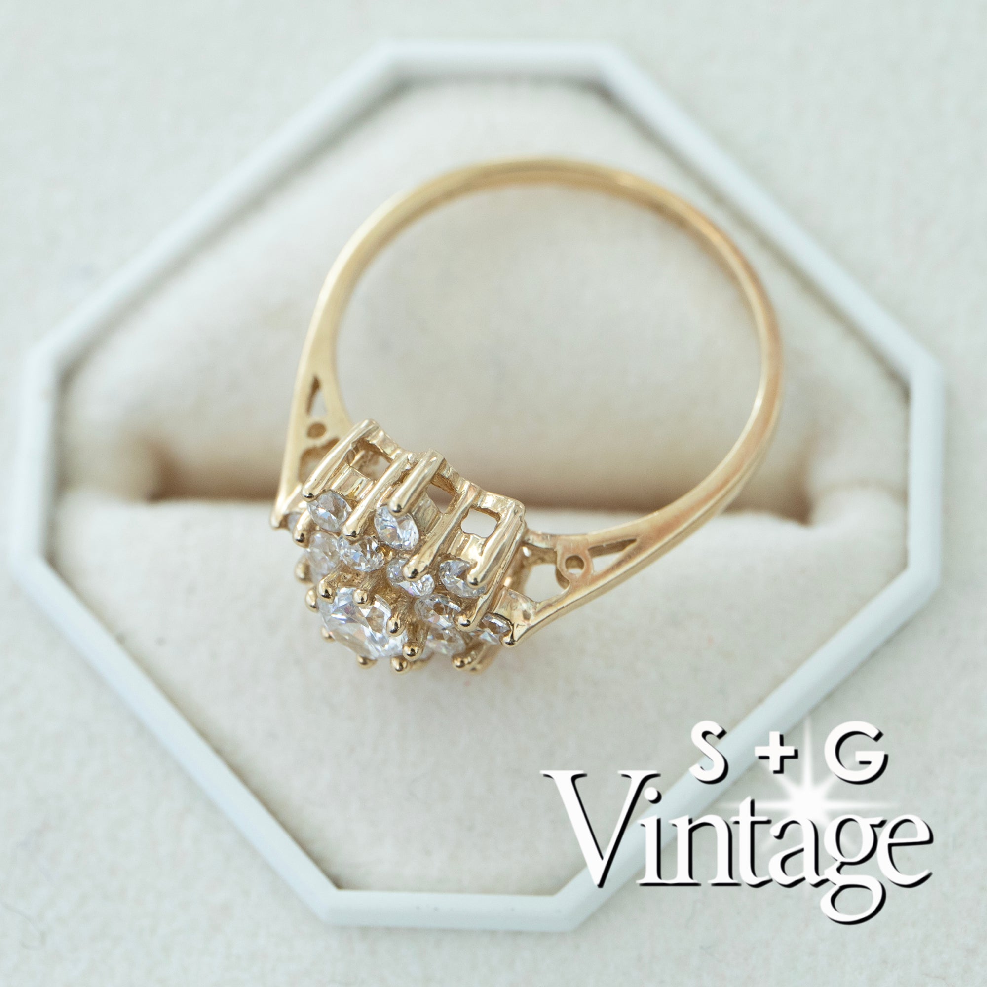 Gold ring with diamonds on a white hexagonal stand, featuring 'S + G Vintage' branding - seolgold