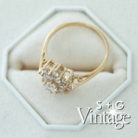 Gold ring with diamonds on a white hexagonal stand, featuring 'S + G Vintage' branding - seolgold