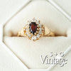 Gold ring with a garnet stone and diamond accents in a white box, branded 'S + G Vintage' - seolgold